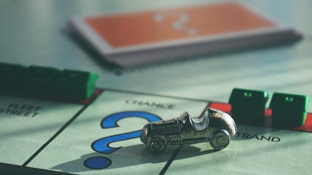 pexels photo 1634213 1634213 A close-up of a Monopoly board game featuring a silver car token and chance card.
