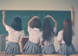 pexels photo 710743 710743 teatro en inglés para secundaria_Group of teenage girls in school uniforms enjoying time together in a classroom, posing with playful gestures.